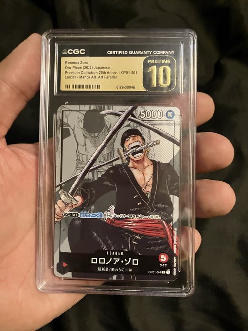 A hand holds a CGC-graded Pristine 10 One Piece (2022) Japanese Premium Collection card featuring Roronoa Zoro, with text noting "OP01-001," "Leader - Manga Atl. Art Parallel," and a power of 5000, recently unboxed as the post mentions.
