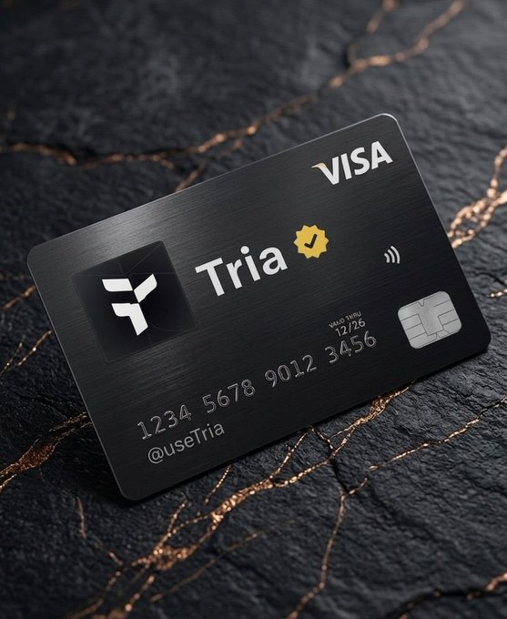 A sleek black Visa-branded metal credit card labeled 'Tria' with the @useTria handle, resting on a dark marbled surface.