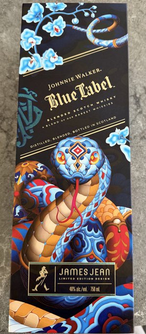 The image features an intriguing blue and gold box of James Jean whiskey, which has been artistically designed to resemble a snake. The box is adorned with a snake design that adds a unique and creative touch to the packaging. The text on the box clearly states "Blue Label" and "James Jean Limited Edition", indicating that this particular bottle of whiskey is a limited edition release from James Jean.