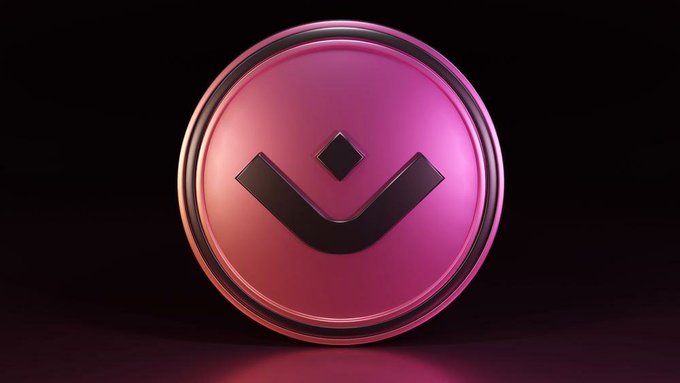 A pink and red metallic circular logo with a chevron/down-pointing arrow design displayed against a black background.