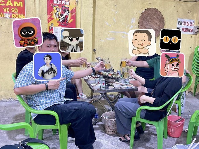 A group of friends cheer with beer glasses at an outdoor table, their faces covered by cartoon stickers, in front of a yellow wall featuring a "Wifi Lẩu & Lẩu Thành Rồng" sign before heading to Saigon.