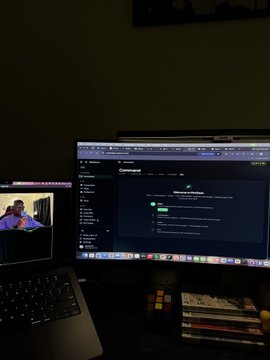 A dimly lit workspace shows two laptops side by side, with the main screen displaying a Command | Decentralized digital dashboard and a stack of books beneath it, while the accompanying post celebrates minting nearly 2,000 NFTs on INK within 10 hours in anticipation of the "#el_click" launch.