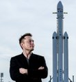 A man in a dark suit and sunglasses stands with arms crossed in front of a SpaceX Falcon 9 rocket on a launch pad under a clear sky, with the company name visible on the launch tower, symbolizing confidence in SpaceX's revival as the post describes the stock recovering to its IPO price of $225 after dropping to $147 and entering the "Accumulation" phase of its market cycle.