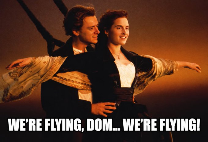 A meme featuring Jack and Rose from the movie Titanic embracing at the ship's bow with arms outstretched, captioned "WE'RE FLYING, DOM... WE'RE FLYING!"