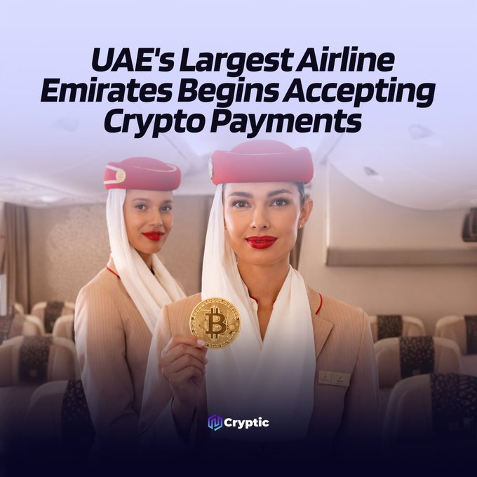Emirates flight attendants in uniform hold a gold Bitcoin coin inside a cabin, under the headline "UAE's Largest Airline Emirates Begins Accepting Crypto Payments." The image visually reinforces the announcement of Emirates partnering with Crypto.com to accept cryptocurrency for flight bookings, with the Cryptic logo displayed at the bottom.