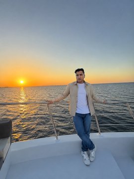 A man stands relaxed on the bow of a boat with arms outstretched against a stunning ocean sunset, embodying the calm confidence of someone who has weathered the crypto market's storms and come out smiling. His leisurely pose contrasts with the cautionary tone of the post, suggesting that experienced traders who avoid common pitfalls can eventually enjoy the rewards.