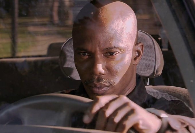 A bald man with a serious expression sits in the driver's seat of a car, gripping the steering wheel while staring intently forward, suggesting a moment of focused investigation or suspicion. His intense gaze visually echoes the post's tone of someone trying to uncover hidden information, as if he's "on the case" of proving Uniswap's alleged self-sabotage in favor of the $PONS token.