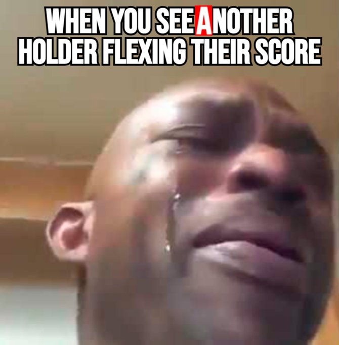 The image shows a person's face with tears streaming down their cheeks as they look at a text message or social media post that reads "When you see A, when you see another holder flexing their score." The person appears to be upset about something related to a competition or contest, possibly due to the comparison of their own score to someone else's.