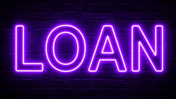 The image features a neon sign that reads "LOAN" written in purple letters against a brick wall background. The text is in a larger font size than usual, making it stand out prominently. The sign also includes an additional line of text that says "We have a champion! After weeks of tournament matchups and community votes, $LOAN takes the crown as the Best token on Metal X". This message emphasizes the significance of the "LOAN" word in the image and highlights its importance or victory.