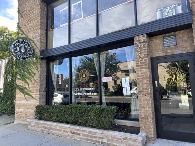 The exterior of a restaurant called 'Fork & Coin Restaurant' is shown, featuring a brick facade, large windows, an 'OPEN' sign, and the website www.forkandcoin.com displayed.