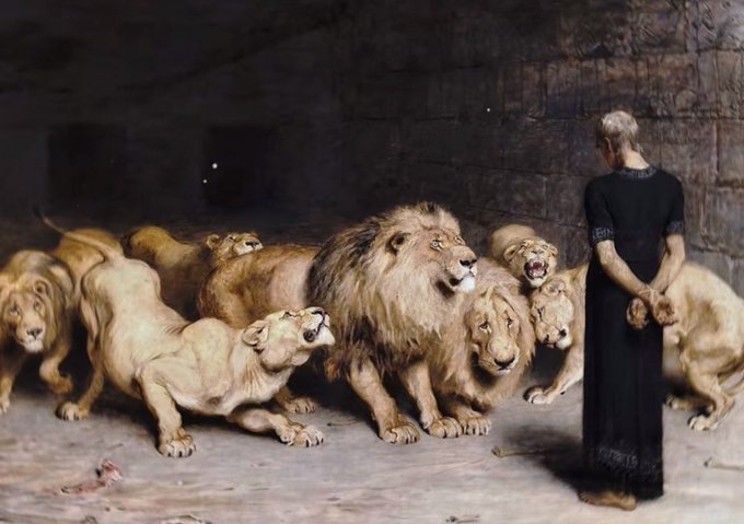 A classic painting depicting a figure in a black robe standing calmly before a group of lions and lionesses in a stone den setting.