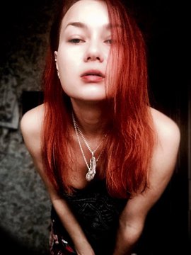 The image features a woman with red hair wearing a black dress and necklace. She has her hands behind her back and appears to be posing for a photo. The caption of the image reads "Gm everyone Happy Sunday #Moon Crow #Available on SOVREIGNERS gallery by @KOLLECTOR_OG 0,33 $ETH Best time to buy crypto and NFT". This suggests that the woman is promoting an event or product related to cryptocurrency and NFTs.