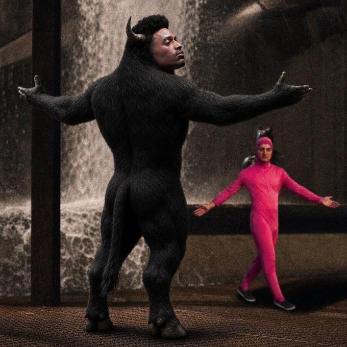The image shows a person dressed as a bull with massive horns and muscles, standing on a road next to another person wearing pink and white clothing who appears to be an anime character from Japan. The bull character seems to have its arms outstretched, while the anime character has her arms spread wide as if waving or dancing. Both characters are in close proximity to each other, creating a visually striking scene that combines elements of strength and dance-like movements.
