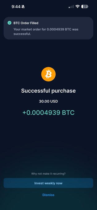 The image shows a phone screen displaying a message about investing in Bitcoin. The text on the screen reads "Successful purchase! 30,000 USDC was paid for 0,000,000 BTC. Now invest wisely!". The background of the image is dark blue with white text and an orange circle that says "btc".