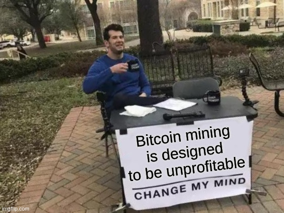 The image shows a man sitting at a table with a sign above him that says "B Bitcoin mining is designed to be unprofitable". The text suggests that Bitcoin mining is not economically viable, as the difficulty adjustment reduces the miners' income each time they move up in the hash rate scale. This makes it difficult for miners to make a profit from their efforts.
