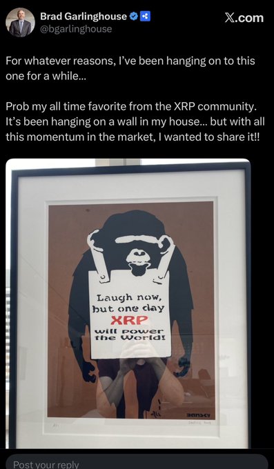 Brad Garlinghouse (@bgarlinghouse) shares a framed Banksy-style artwork of a chimp holding a sign reading "Laugh now, but one day XRP will power the world," celebrating his favorite piece from the XRP community as the post highlights delusional crypto communities winning the bull cycle.
