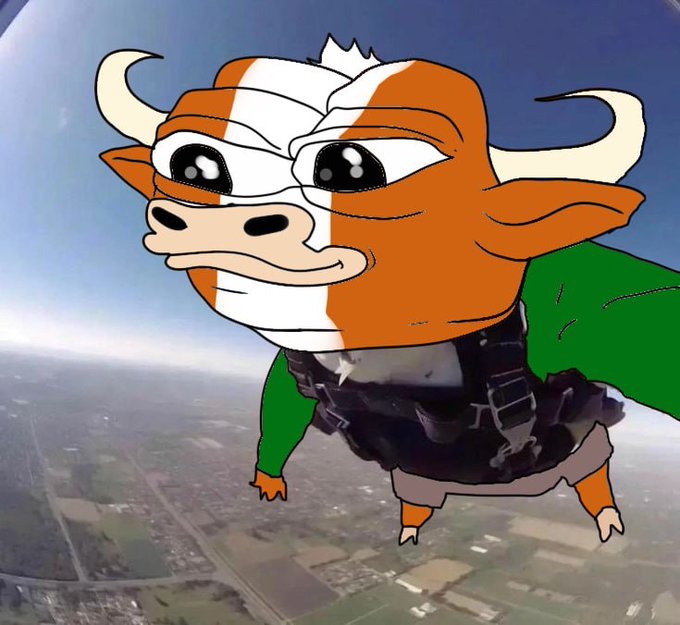 A humorous, surreal image of a cartoon cow character wearing a skydiving harness and green sleeves, appearing to skydive over a landscape far below.