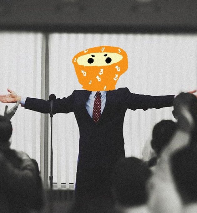 A person in a business suit with arms outstretched before an audience, with their head replaced by a crudely drawn cartoon orange with eyes.