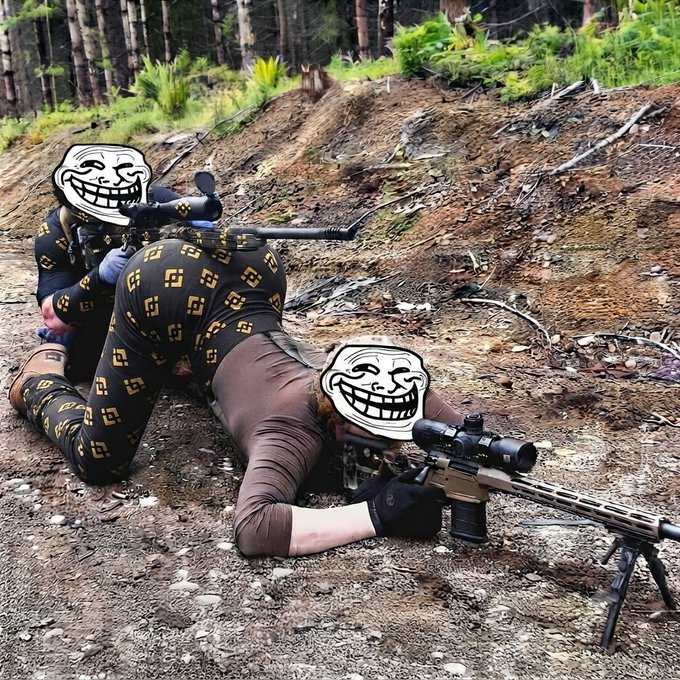 Two people in tactical gear lying prone on a dirt embankment with rifles, their faces obscured by troll face memes.