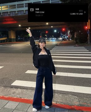 A young woman poses on a city crosswalk at night in a black outfit and cap, throwing a peace sign, while a TRUMP.COM price ticker showing -2,460.15 USD and a Chinese stock chart overlay appear at the top.