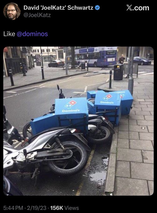 A tweet from David 'JoelKatz' Schwartz (@JoelKatz) shows Domino's pizza delivery scooters parked along a UK street, with the caption "Like @dominos." The accompanying post suggests a conspiracy-themed commentary about events in Japan, playing on the "dominoes falling" metaphor with the visible Domino's branding.