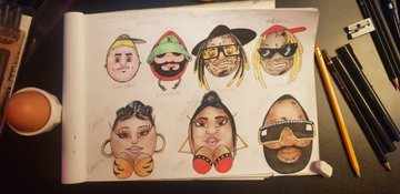 A photograph of a sketchbook page featuring hand-drawn sketches of surfboards decorated with various character faces and designs.