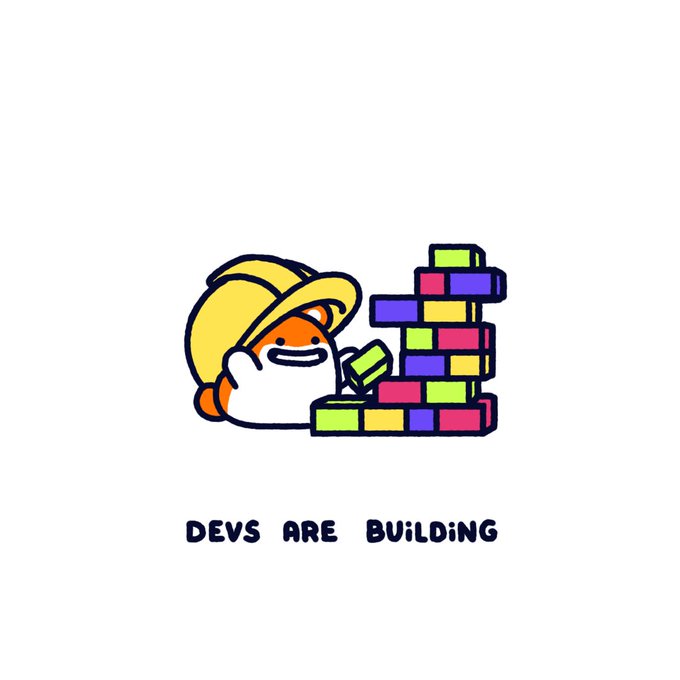 A cartoon character wearing a yellow hard hat stacks colorful blocks, with the caption "DEVS ARE BUILDING" displayed below. The image visually reinforces the post's message about Tomochi's ongoing development and commitment to expanding its presence as a mainstream IP.