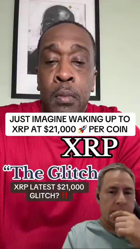 The image features a man wearing a red shirt, with another person partially visible behind him. They are both looking at something off-camera, possibly discussing or reacting to an event or situation. The background of the image includes a picture frame on the wall above them and a text overlay that reads "Just imagine waking up to XP @ 21k per coin". This suggests that they might be talking about cryptocurrency trading or investing in it.
