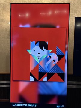 A red NFT digital art display featuring a stylized geometric portrait with blue and pink tones, labeled 'LAZZYYO.GOAT NFT' at the bottom.