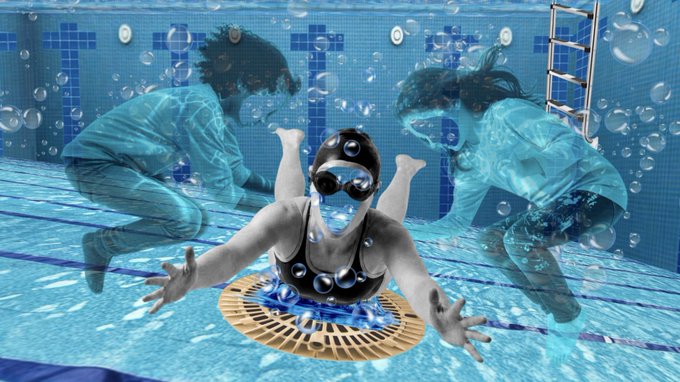 A swimmer wearing goggles swims underwater toward the camera over a pool drain, while two ghostly blue-tinted figures appear to float in the background amid rising bubbles.
