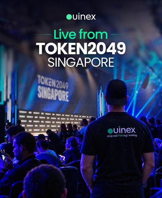 Marketing image for uinex 'Live from TOKEN2049 SINGAPORE' showing a person wearing an uinex branded shirt facing a stage with the event branding displayed on screen.