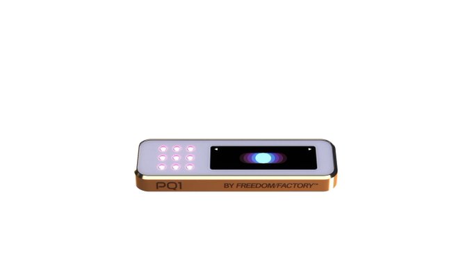 A small electronic device with an orange and silver body features a 3x3 grid of purple LED buttons on the left and a glowing blue display on the right, labeled "PQI" and "BY FREEDOM FACTORY™" along the front.