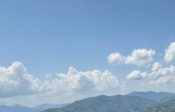 The image shows a beautiful view of mountains under a clear blue sky with white clouds, creating a serene atmosphere. The scene captures the essence of nature's beauty and tranquility. The caption above the image provides information about a new technology that is revolutionizing the computing industry by connecting hardware to networks in a more efficient manner.