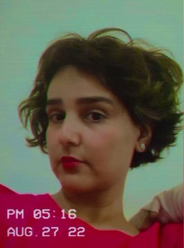 A vintage-style photo of a woman with short curly brown hair, timestamped 'PM 05:16 AUG. 27 22'.