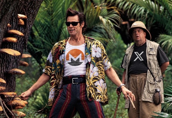 Actor Jim Carrey stands in a tropical jungle wearing a Monero (XMR) cryptocurrency logo shirt and floral Hawaiian shirt, with actor Alan Cumming in a Monero X shirt visible behind him.