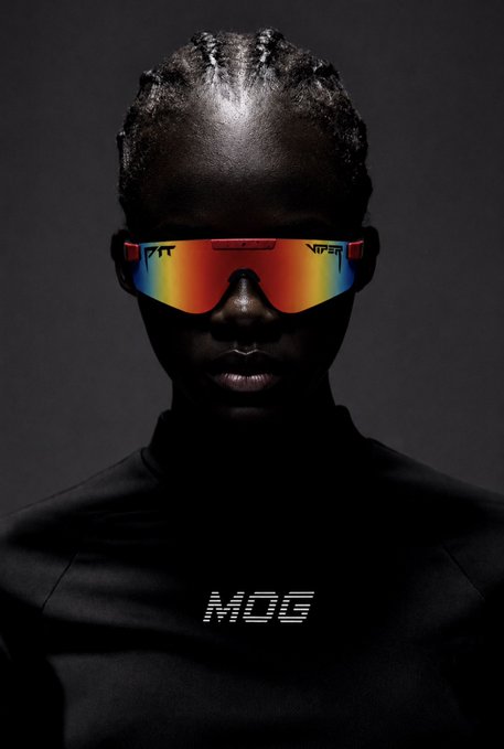 A model wears futuristic reflective Pit Viper sunglasses that flash a rainbow spectrum across the lenses, paired with a black top featuring the bold "MOG" logo on the chest, perfectly embodying the confident, no-nonsense mantra "Mog it or leave it."