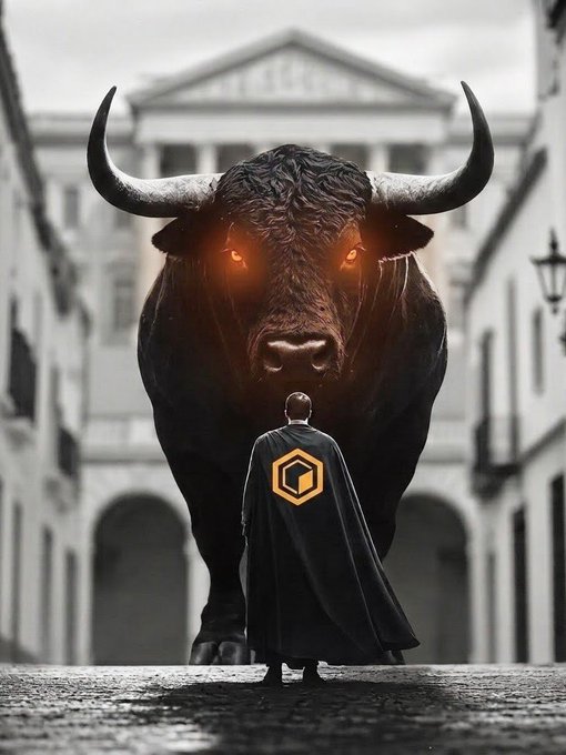 A dramatic digital artwork depicting a person wearing a black cape with an orange hexagonal logo standing before a massive dark bull with glowing orange eyes in a monochromatic urban street setting.