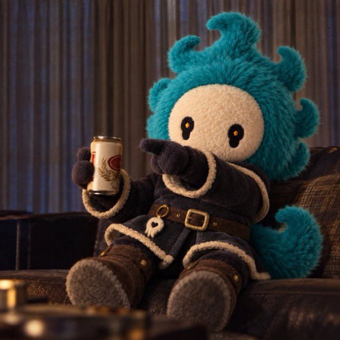 A fluffy teal plush character with a cream-colored face lounges on a couch in a dark blue fur-trimmed coat, holding a beverage can. The creative plush scene fits the giveaway's request for users to stage imaginative scenarios featuring their plushies to win 5 Ghost free mints worth $250.