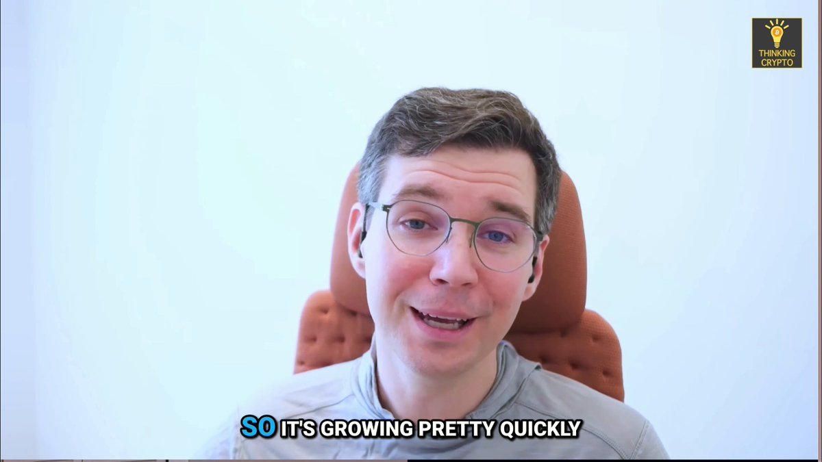 The image shows a man wearing glasses sitting in an office chair with his head tilted back as if he's smiling or posing for a photo. The background of the image is white, which contrasts with the brown color of the chair. There are also some text elements present on the image that read "So it's growing pretty quickly" and "@Austin_Federa @thinkcryptopod".