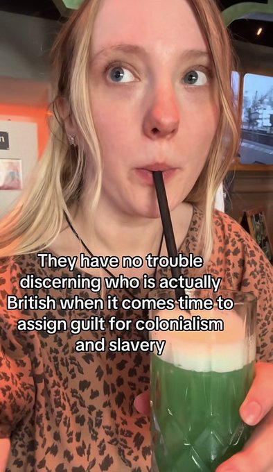 A blonde woman drinks a green beverage through a black straw, with overlaid text reading: 'They have no trouble discerning who is actually British when it comes time to assign guilt for colonialism and slavery'.