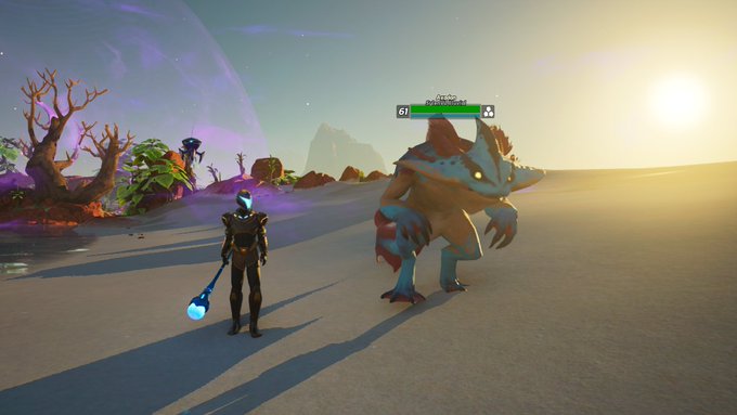 A video game scene shows a player character holding a glowing blue staff facing a large reptilian creature on a beach, with a health bar reading '61' above the creature.