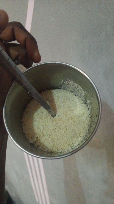 A hand dips a spoon into a stainless steel cup filled with what appears to be garri—a popular West African cassava-based food—visually punctuating the joke about taking "$GARRI" on-chain as if it were a tradable asset. The image cleverly literalizes the meme, turning the staple meal into the "investment" being hyped.
