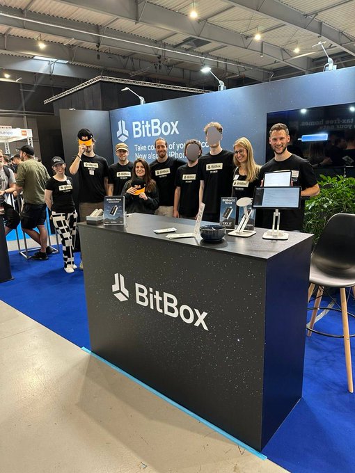 The image shows a group of people standing around a booth for BitBox, an online wallet service. There are at least nine individuals present, with some posing for photos while others engage in conversation. The booth itself has a black countertop displaying information about the service and possibly showcasing their products or services. A chair is also visible near the booth.

The post related to this image emphasizes the importance of understanding how hardware wallets work within the context of Bitcoin, as it appears that the group of people at the BitBox booth are trying to educate others on the topic. The post suggests that users should be aware of the risks associated with not having a hardware wallet and highlights the significance of taking 10 days to @BTCPrague to learn more about their hardware wallet service.