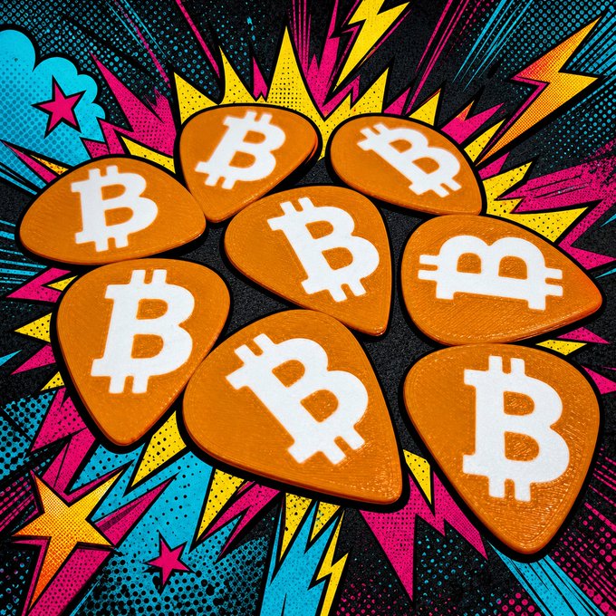 Seven orange guitar picks featuring the Bitcoin '₿' symbol are arranged on a vibrant, comic-style background with lightning bolts and stars.