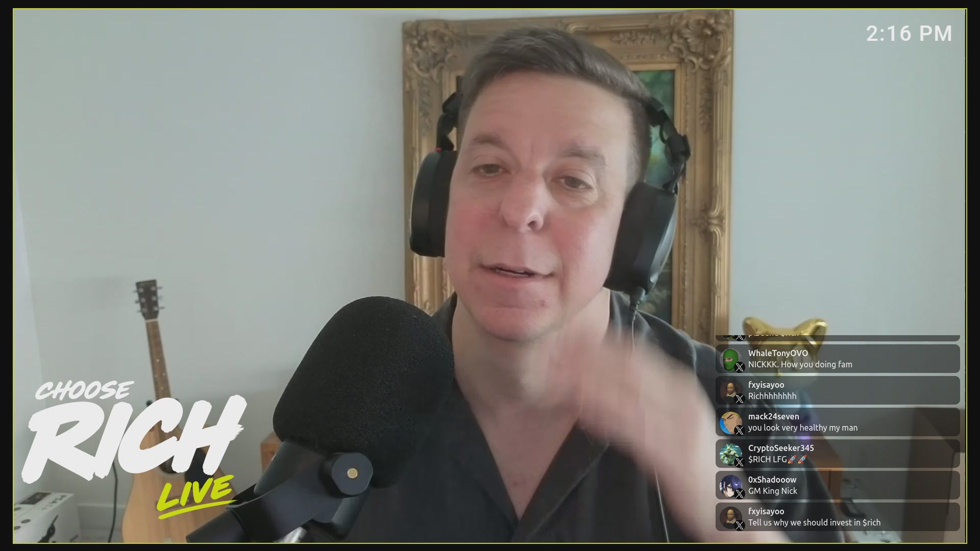 The image features a man wearing headphones, sitting behind a microphone while talking into it during a live stream or radio show. The background of the image shows a white wall with a picture hanging above him. There are also some text elements visible on the screen, including "Choose Rich Live" and "Michael Saylor's Ponzi Nears Total Collapse".