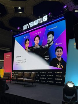 A conference stage with empty chairs set up for a panel discussion, a large screen displaying the 'MY'SWE' logo and panelists including 'Tin Pei Ling', 'Christopher', and 'Dexter', with event branding for 'SCS x SGTECH' and 'BeReady BeBold Be the Next' visible.