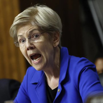 Sen. Elizabeth Warren, wearing a blue blazer and glasses, speaks passionately during a Senate hearing where she criticized the CLARITY Act, arguing that the U.S. needs crypto legislation but not the form the act currently takes.