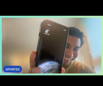 A video thumbnail or meme showing a smiling man looking at a smartphone screen with a voice recording interface, branded with 'umeirzz' watermark in the corner.