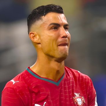 Cristiano Ronaldo, wearing a red Portugal jersey, shows a tearful emotional expression during a match.