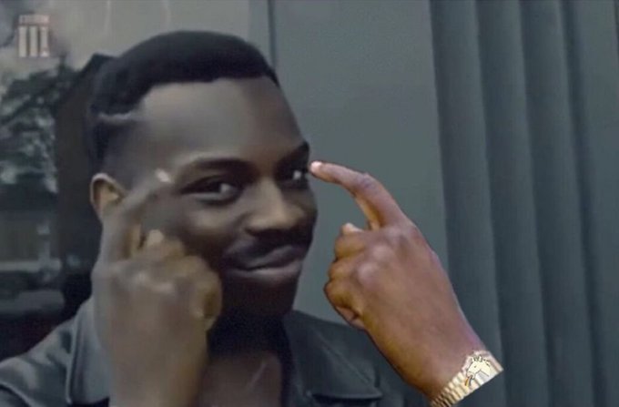 A person pointing at their eye next to a large cutout or screen showing a smiling Black man's face, in what appears to be a humorous social media clip.